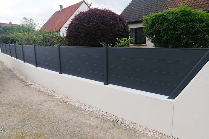 Comment fixer des poteaux de clôture sur muret ?